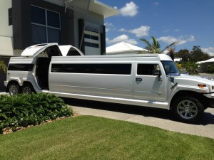 20 seater White hummer limousine parked on driveway with open doors