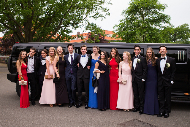 stylish prom group posing with black hummer limo