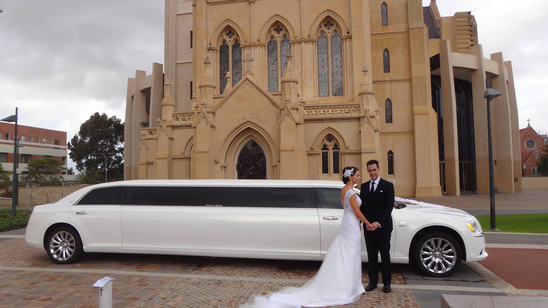wedding couple with limousine at church